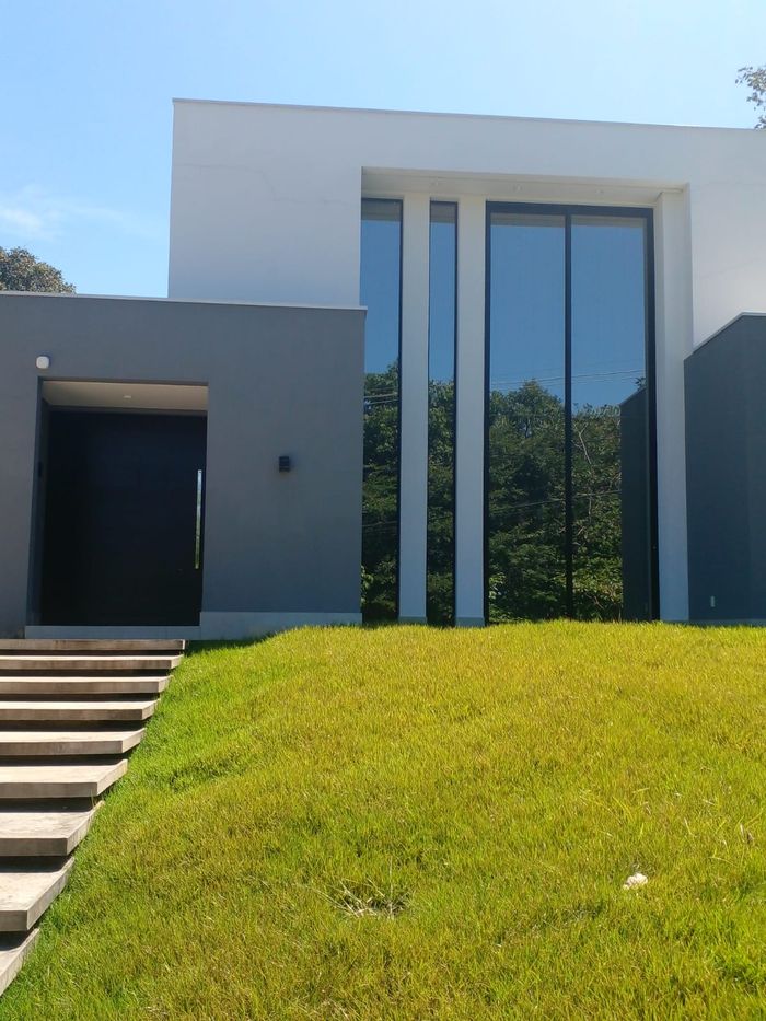 Fachada residencial com janelas altas em alumínio preto